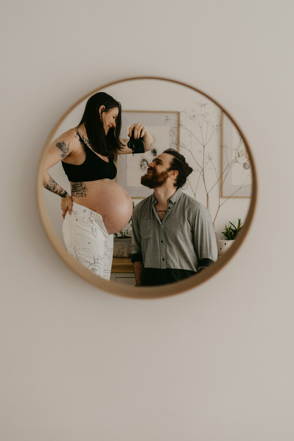 a man and a woman standing in front of a mirror