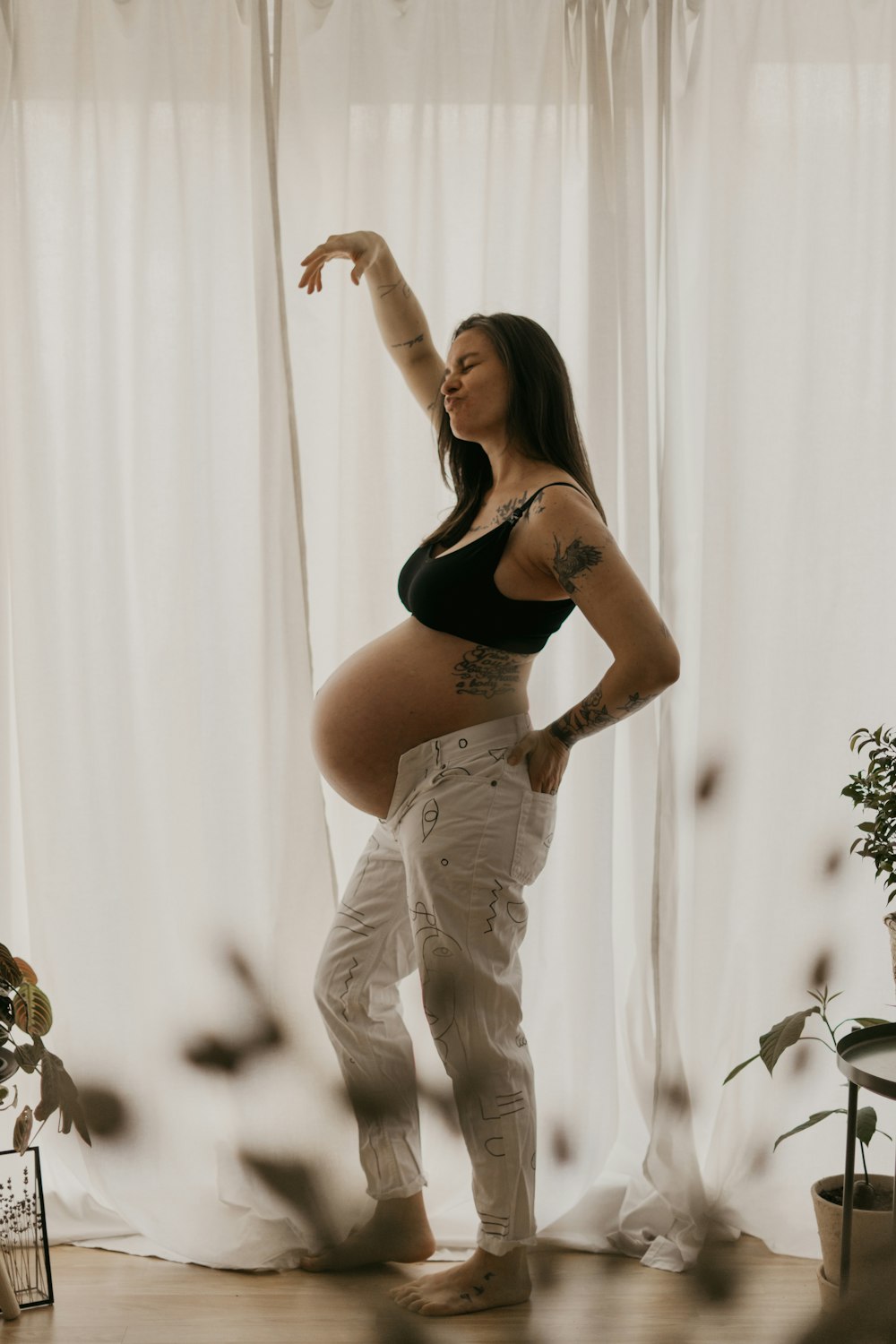 a pregnant woman standing in front of a window