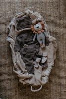 a stuffed animal laying on top of a pile of clothes