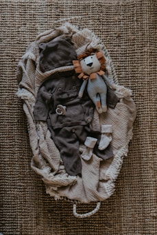 a stuffed animal laying on top of a pile of clothes