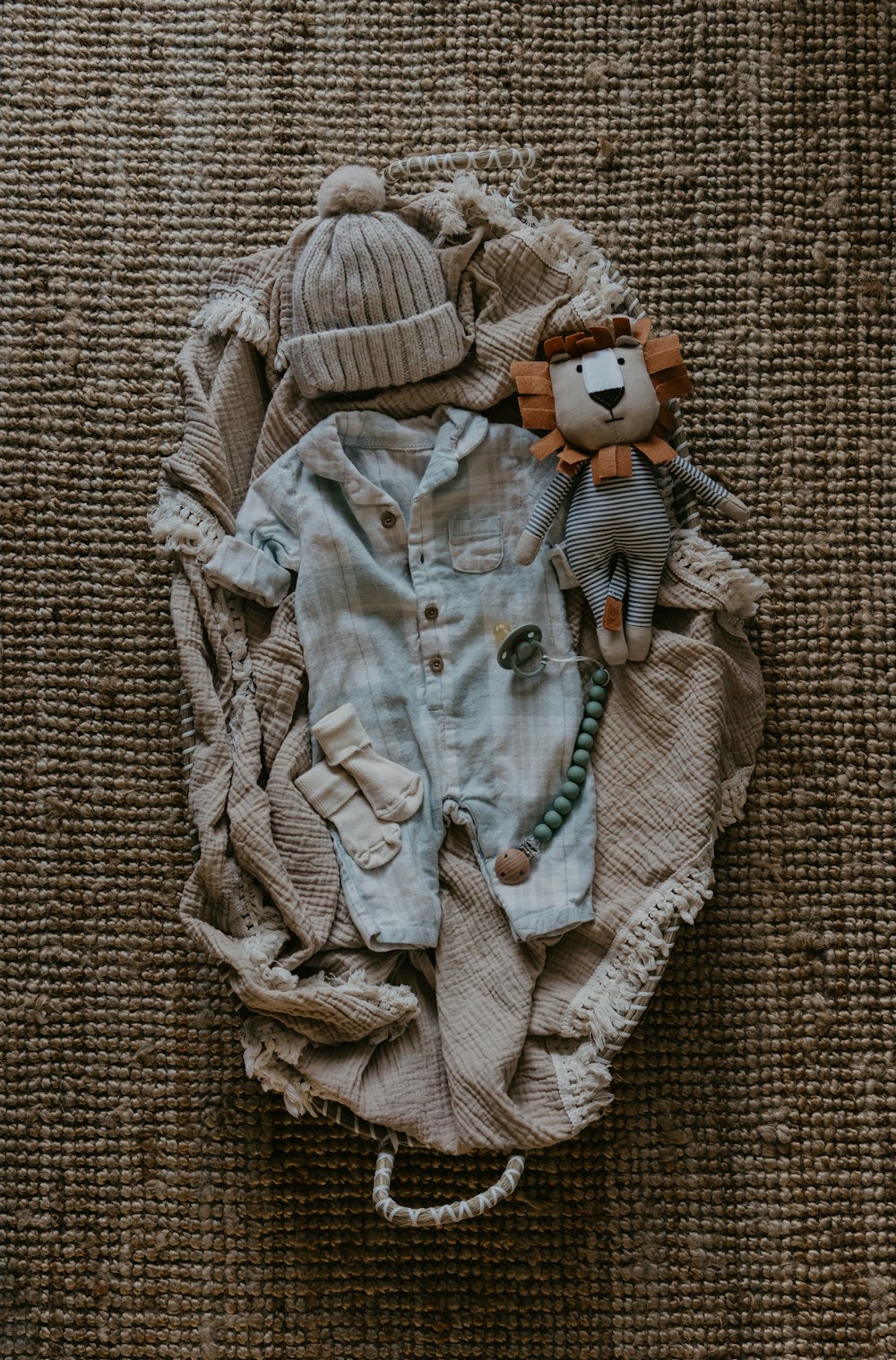 a teddy bear laying on top of a pile of clothes