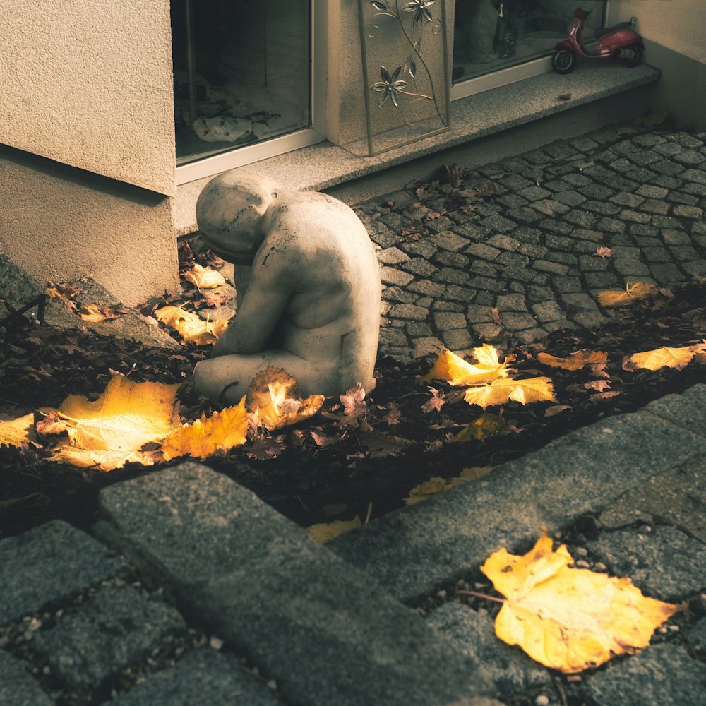 a teddy bear sitting on the ground in front of a building