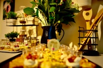 a table topped with plates of food and a vase filled with flowers