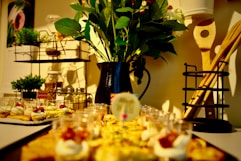 a table topped with plates of food and a vase filled with flowers