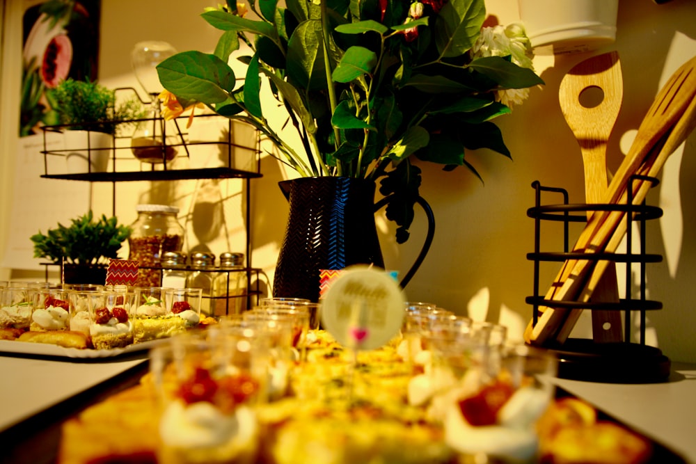 a table topped with plates of food and a vase filled with flowers