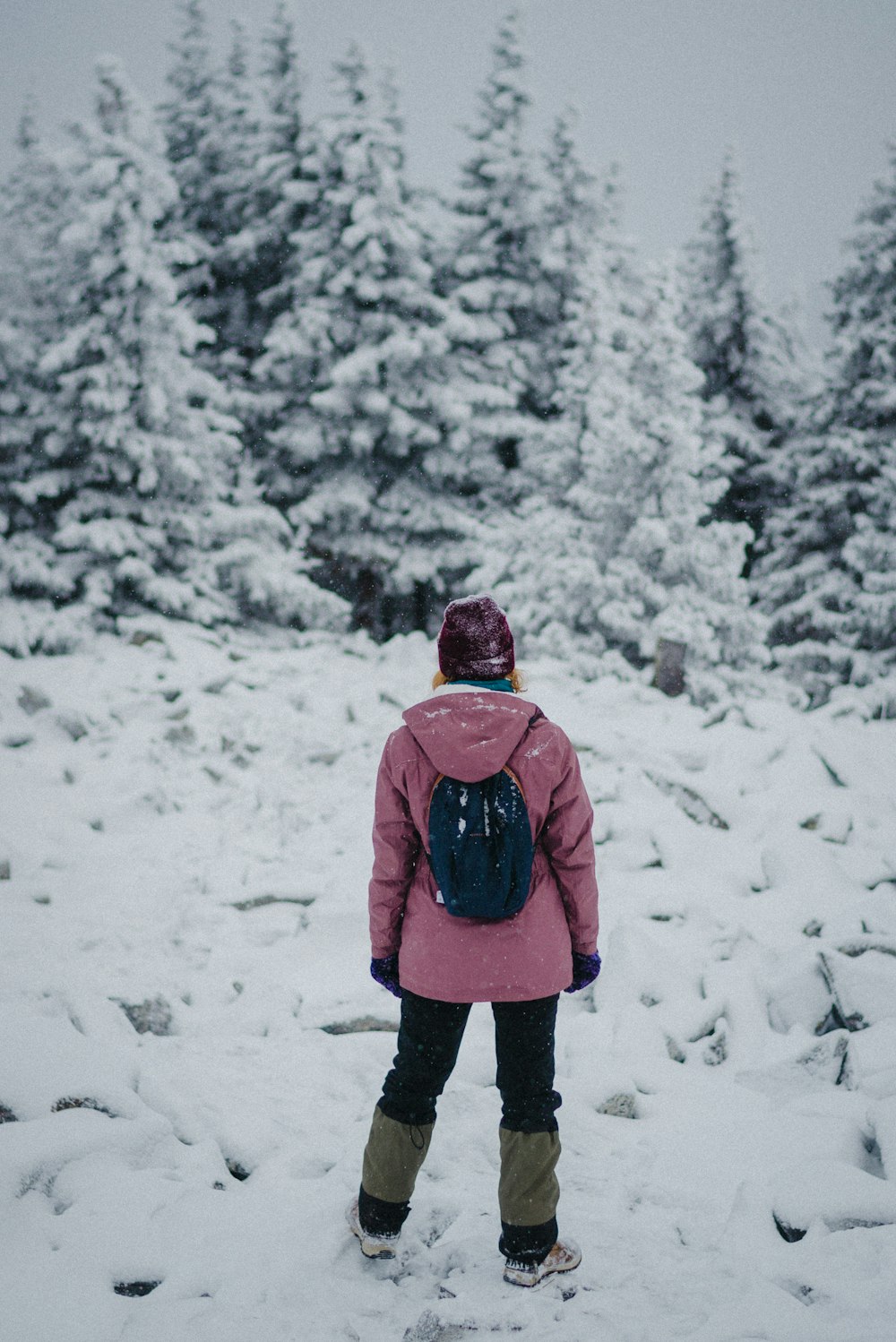 a person standing in the snow with a backpack