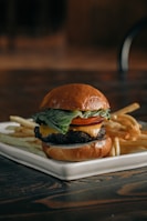a cheeseburger and fries on a plate on a table