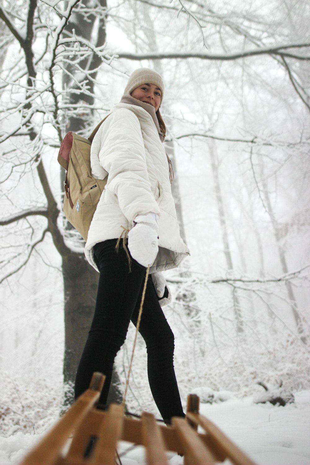 Una donna che cammina attraverso una foresta coperta di neve