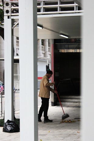 a man with a mop is cleaning the sidewalk