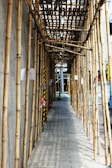 a row of bamboo poles lined up along a sidewalk