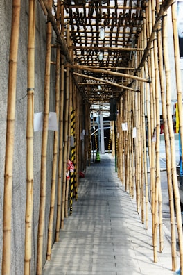 a row of bamboo poles lined up along a sidewalk