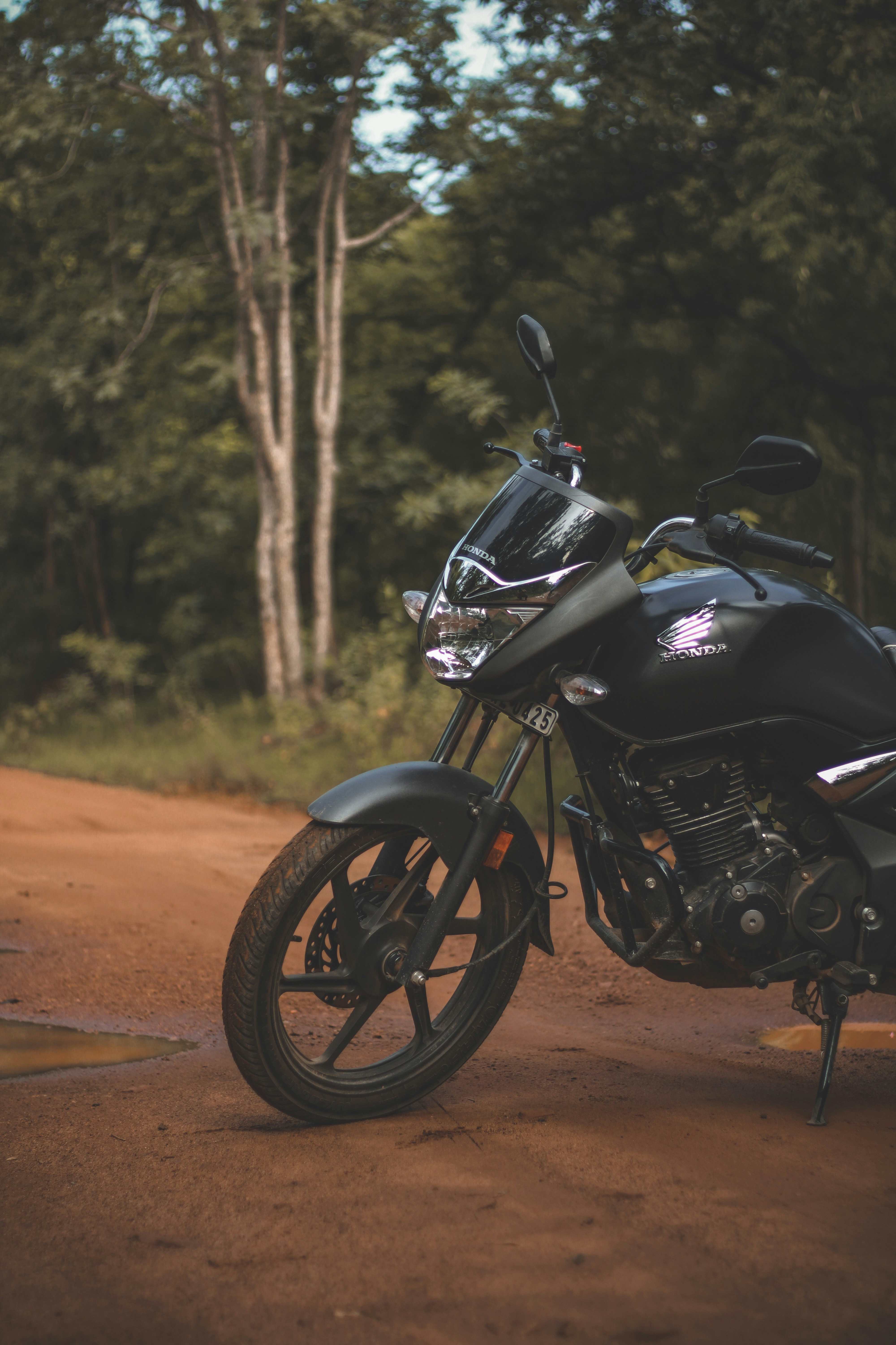a black motorcycle parked on a dirt road