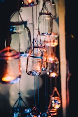 A set of colorful, hand-painted glass jars repurposed as charming candle holders.