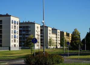 a row of apartment buildings sitting next to a lush green park