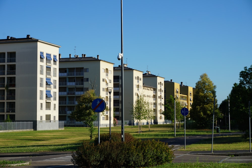 a row of apartment buildings sitting next to a lush green park