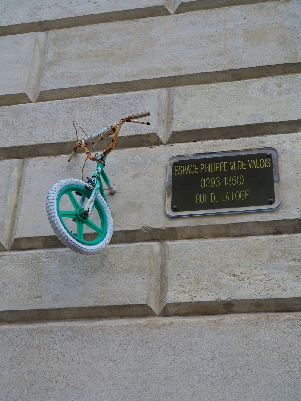 a green bike mounted to the side of a building