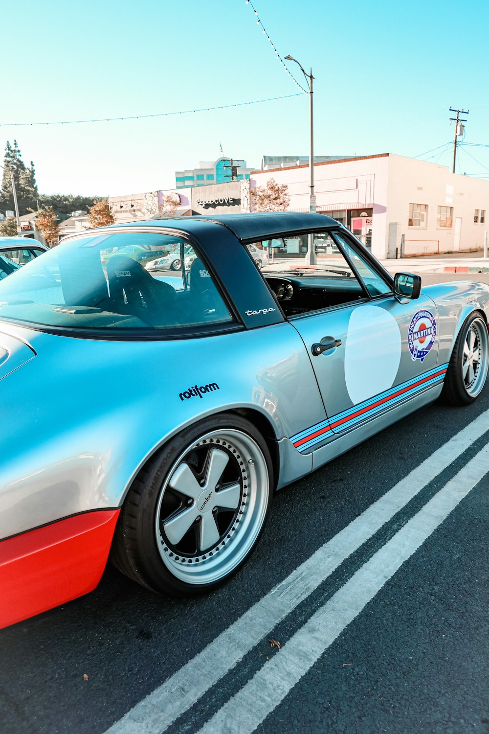 a blue and red sports car parked in a parking lot