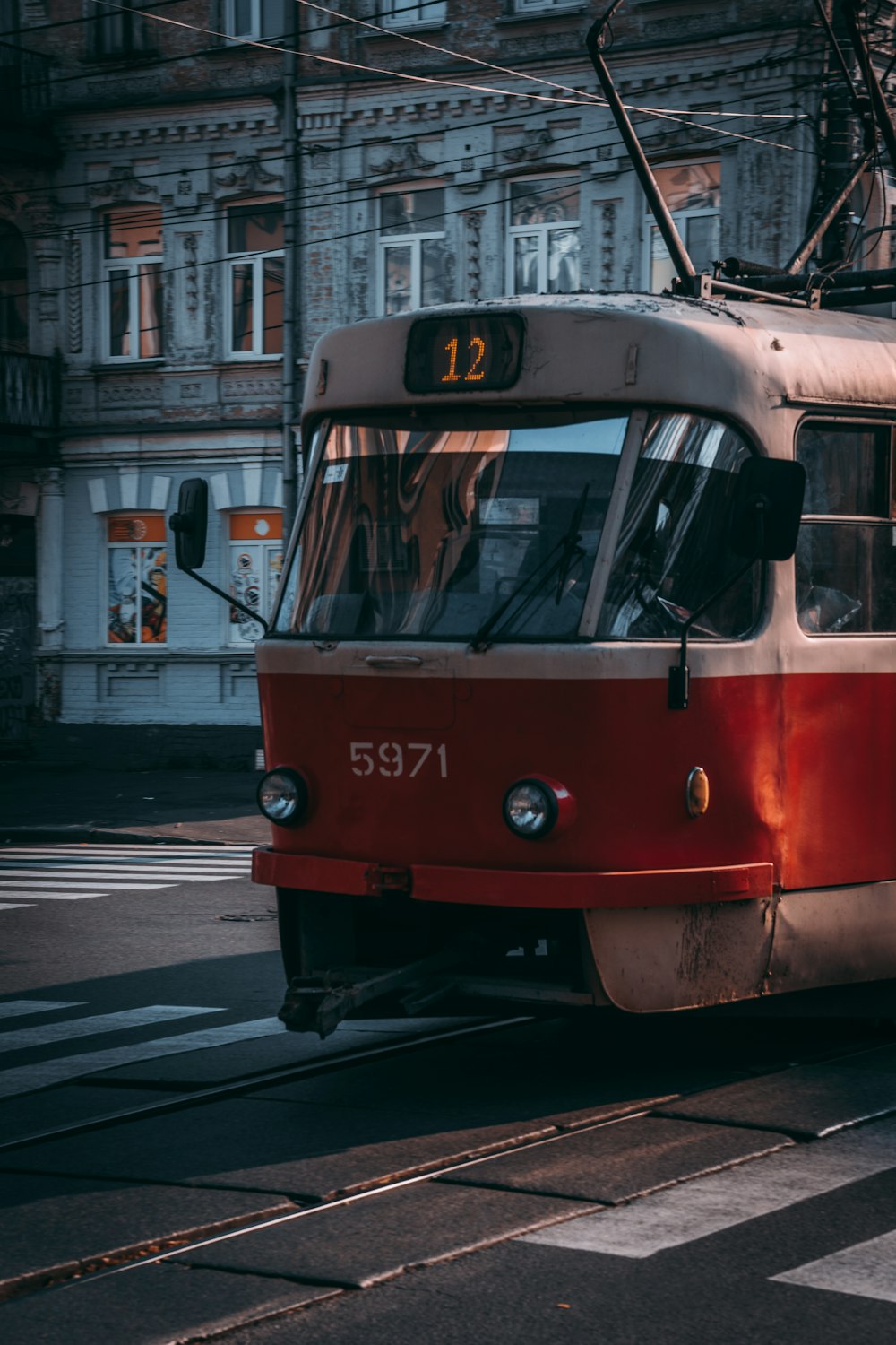 a red and white train traveling down a street