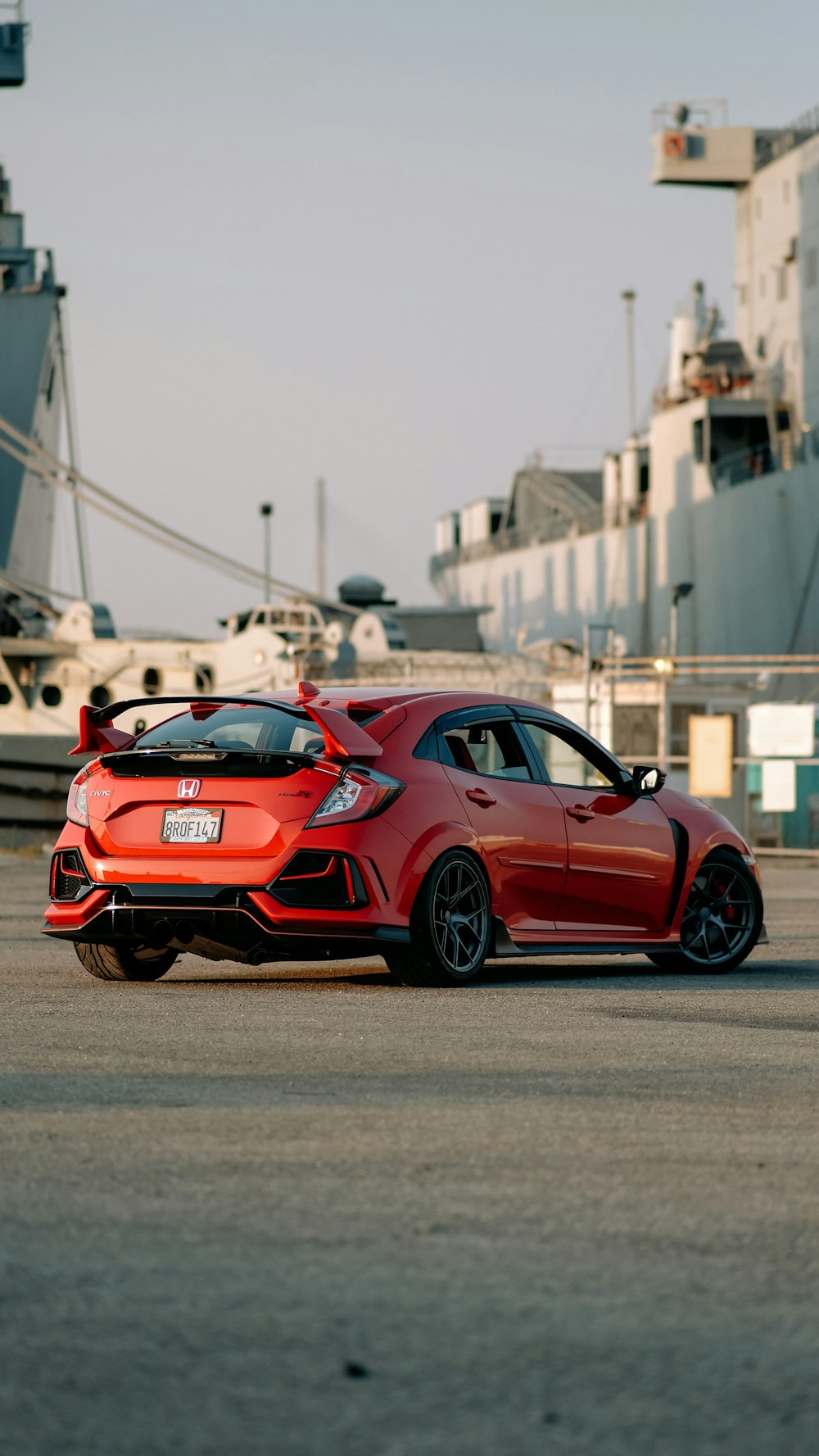a red sports car parked in front of a ship