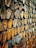 A dense arrangement of rusty, rectangular metal brackets stacked closely together, with chipped paint in shades of yellow and orange, creating a textured and industrial appearance.