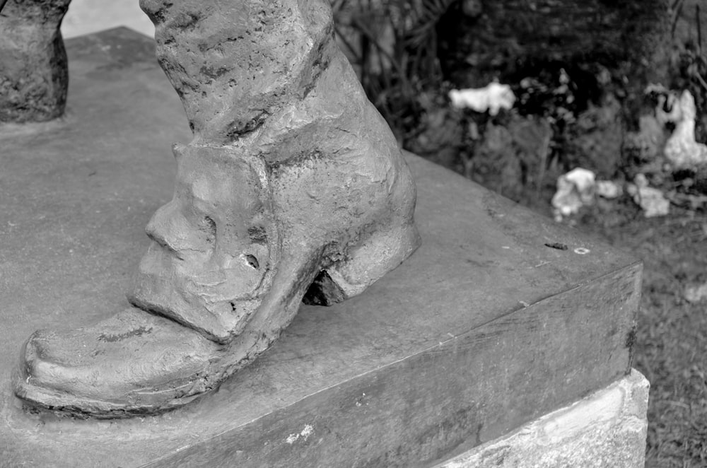 a black and white photo of a foot statue