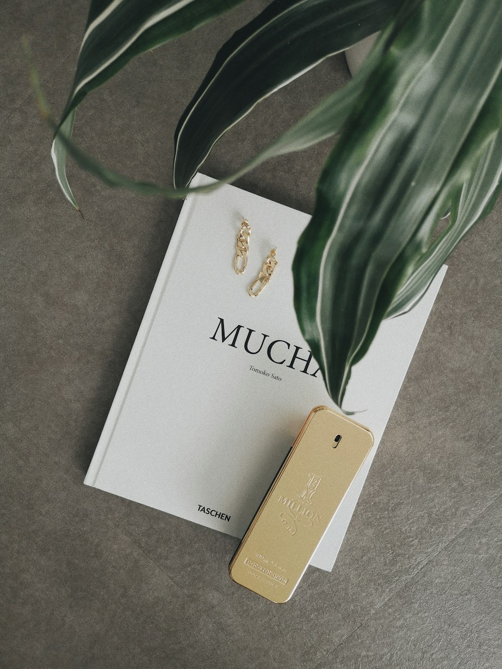 a pair of gold earrings sitting on top of a book