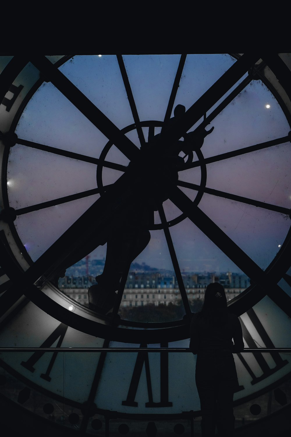 a person standing in front of a large clock