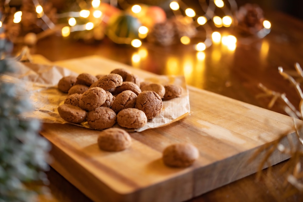 a wooden cutting board topped with cookies on top of a table