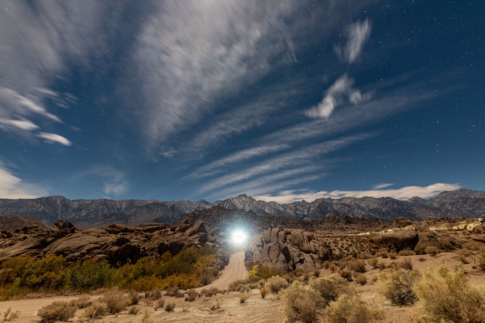 a view of a desert with mountains in the background