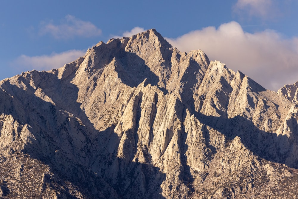 a very tall mountain with some clouds in the sky