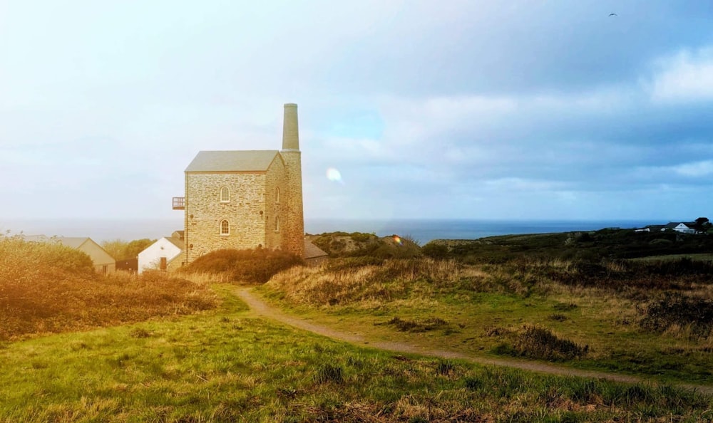 a stone building sitting on top of a lush green hillside