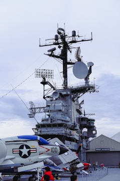 a large military ship with a lot of people around it