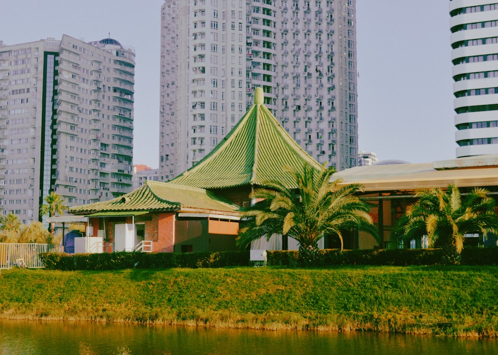 a building with a green roof next to a body of water