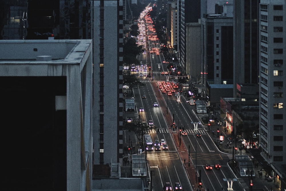 a city street filled with lots of traffic next to tall buildings