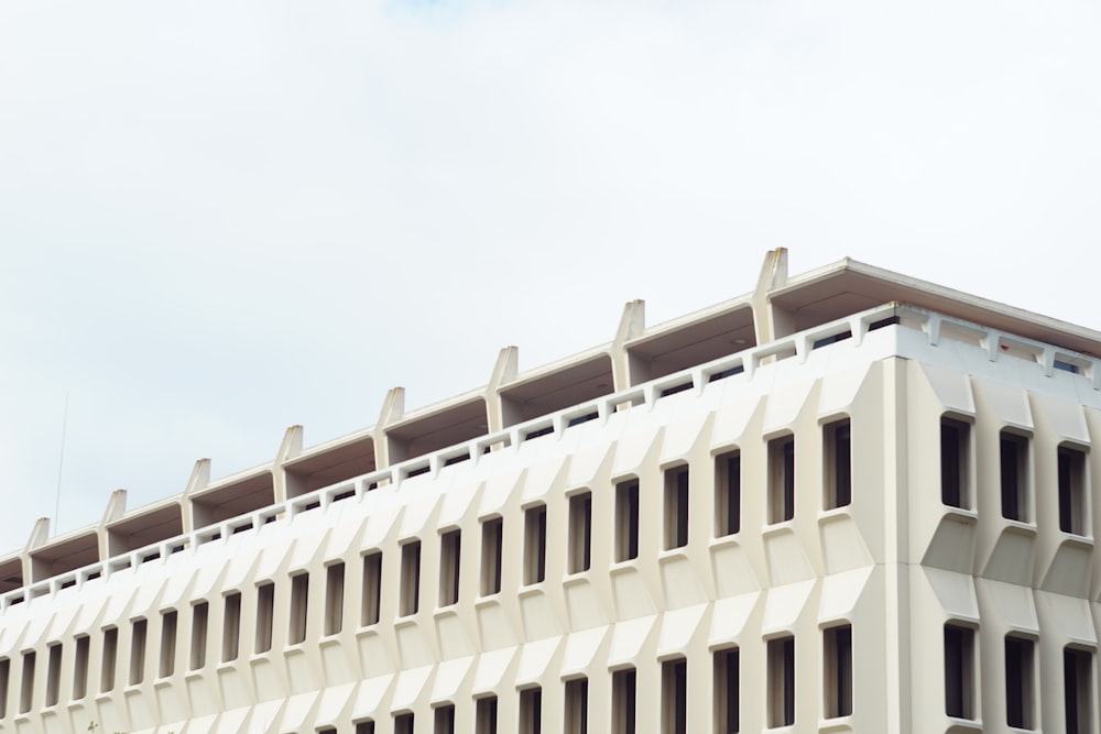 a large white building with many windows and a sky background