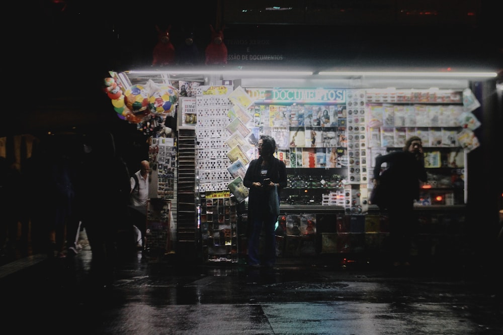 a person standing in front of a store at night