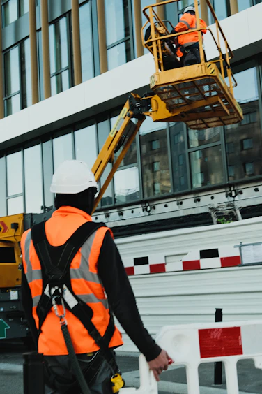 a man in an orange safety vest standing in front of a building