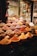A vibrant display of various spices and herbs in a market setting, featuring bowls and piles overflowing with colorful powders and whole spices. The array is both rich and diverse, capturing the essence of a bustling spice market.