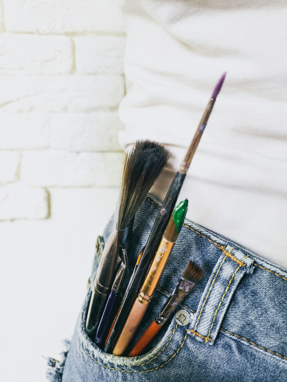 a pair of jeans with a pocket full of brushes