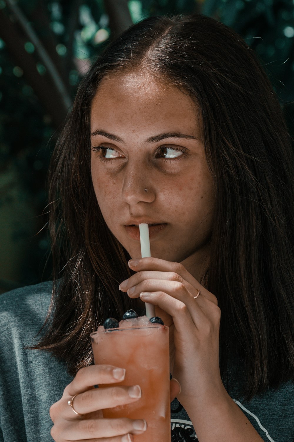 Eine Frau, die mit einem Strohhalm im Mund einen Drink trinkt