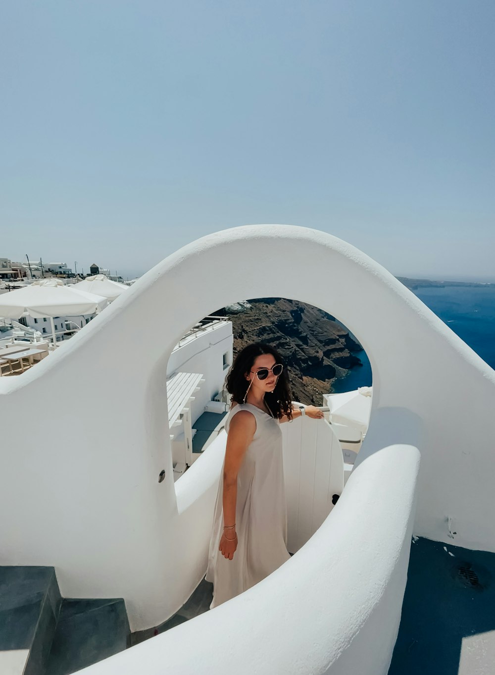 Une femme en robe blanche debout sur un balcon