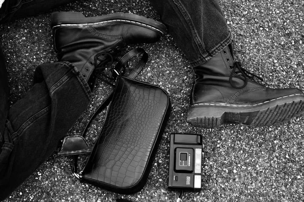 a black and white photo of a pair of boots and a camera