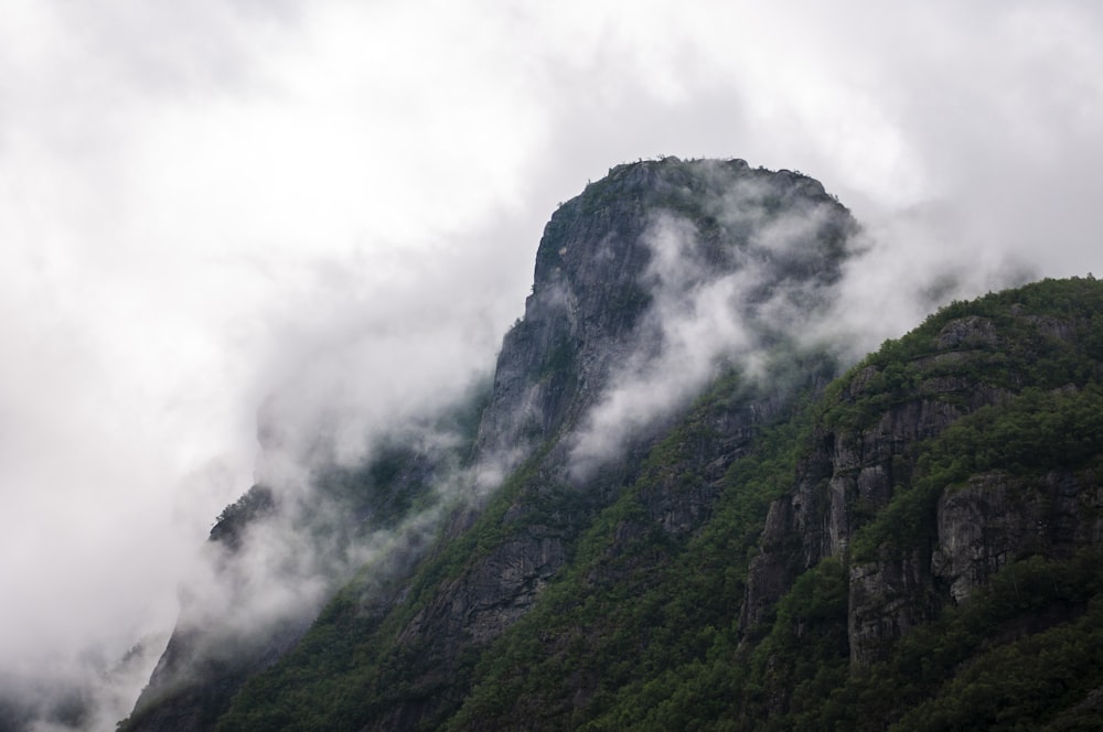 a mountain covered in fog and clouds on a cloudy day