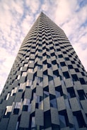 a very tall building with many windows and a sky background