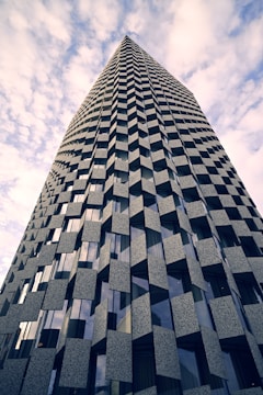 a very tall building with many windows and a sky background