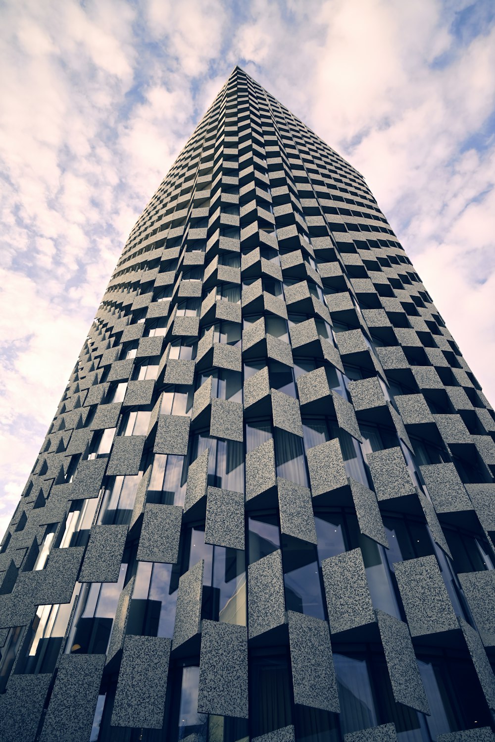 a very tall building with many windows and a sky background