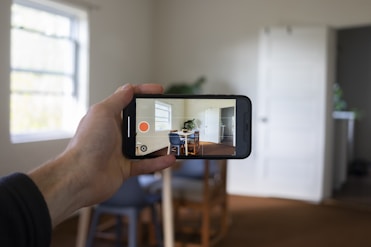 a person holding a smart phone up to take a picture