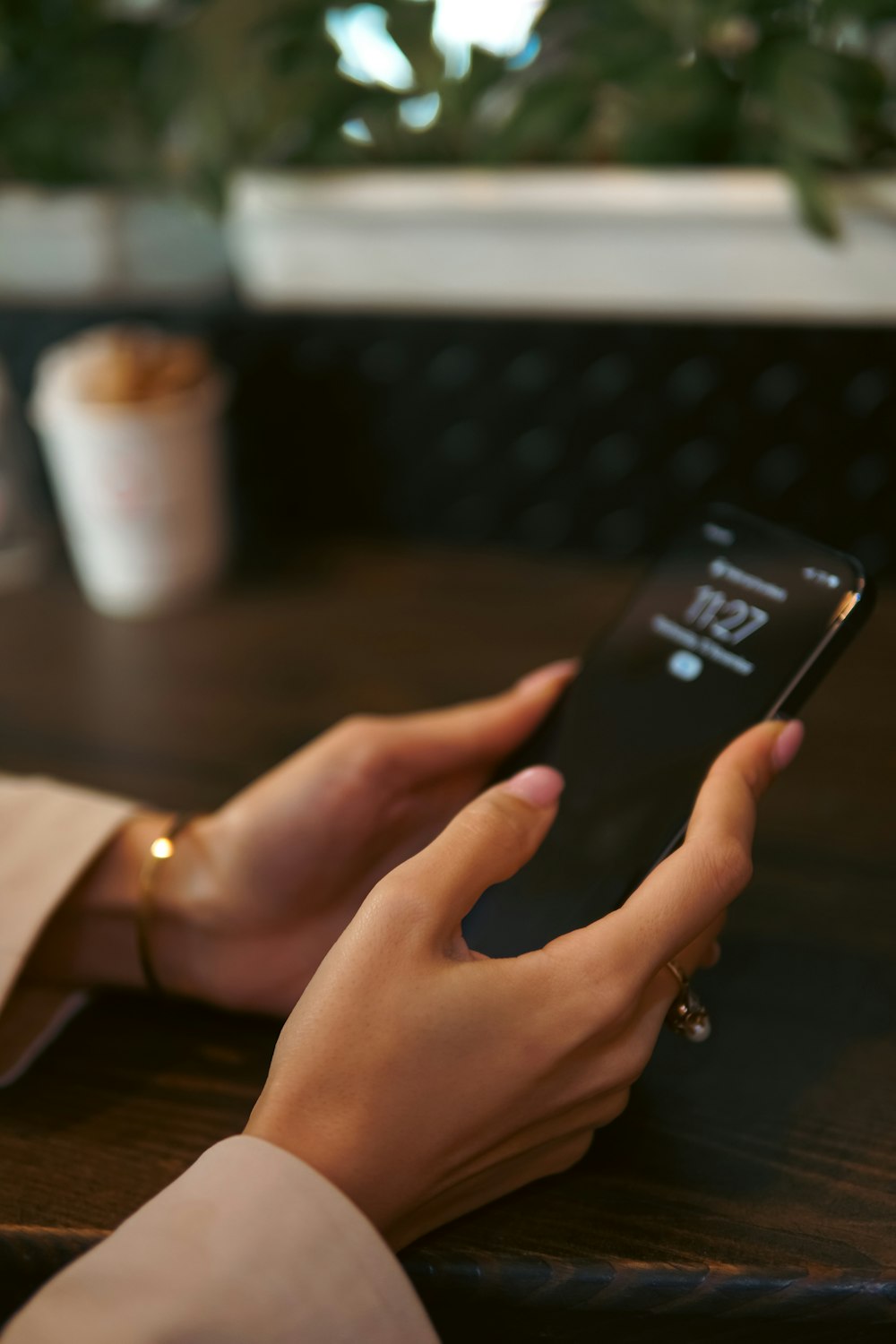 a person holding a cell phone at a table