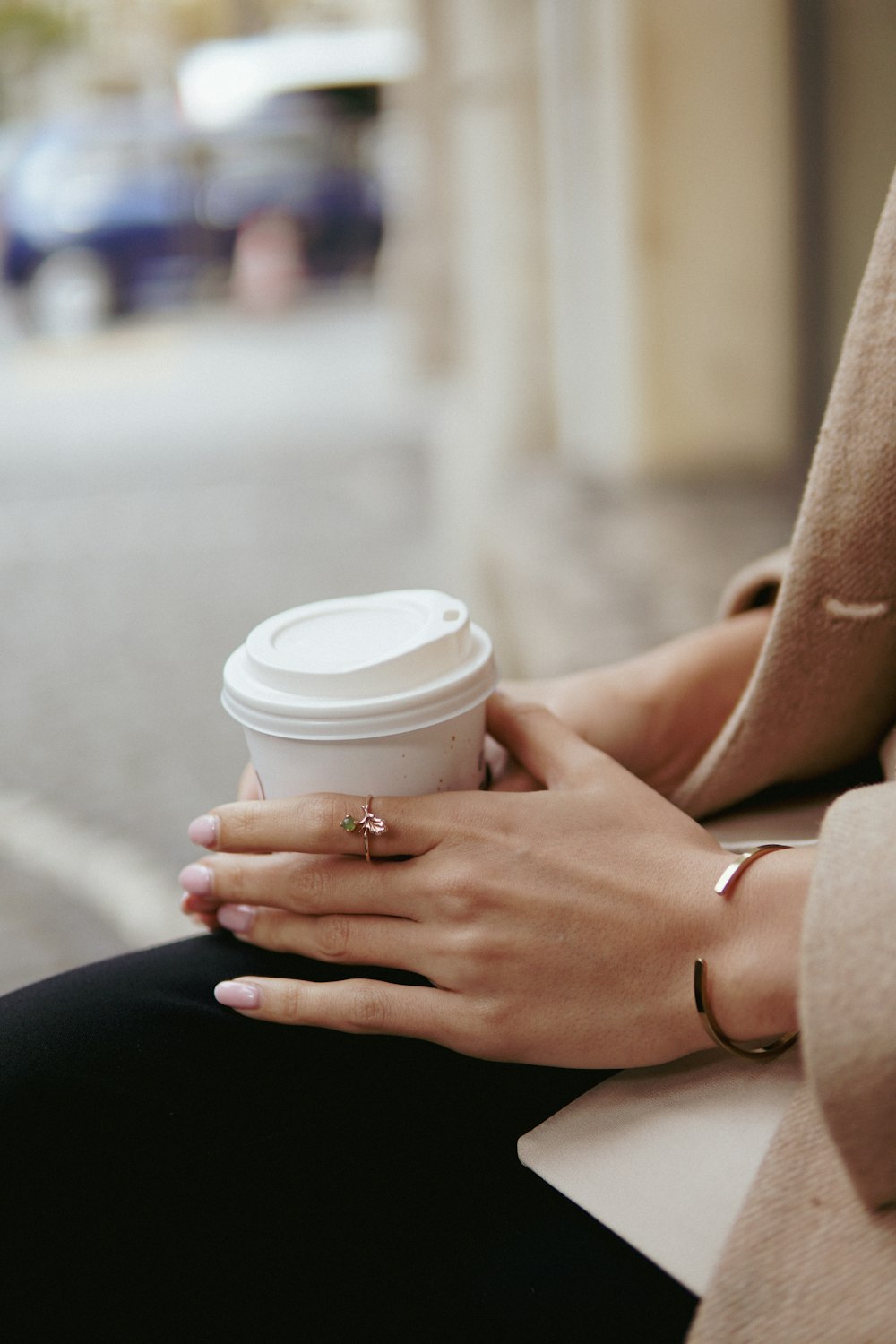 a woman is holding a cup of coffee