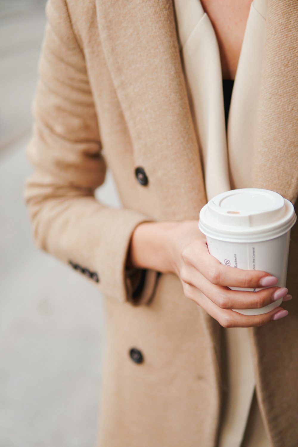 a woman is holding a cup of coffee